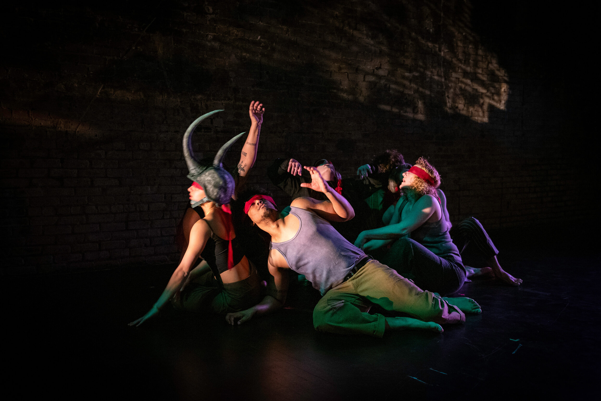 Pangea World Theater actors move 'blindly' as a single rhinoceros in a political satire.